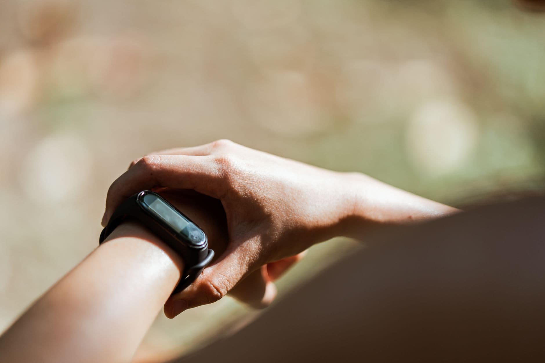 Pulsera inteligente en la muñeca de una persona al aire libre, a la luz del sol
