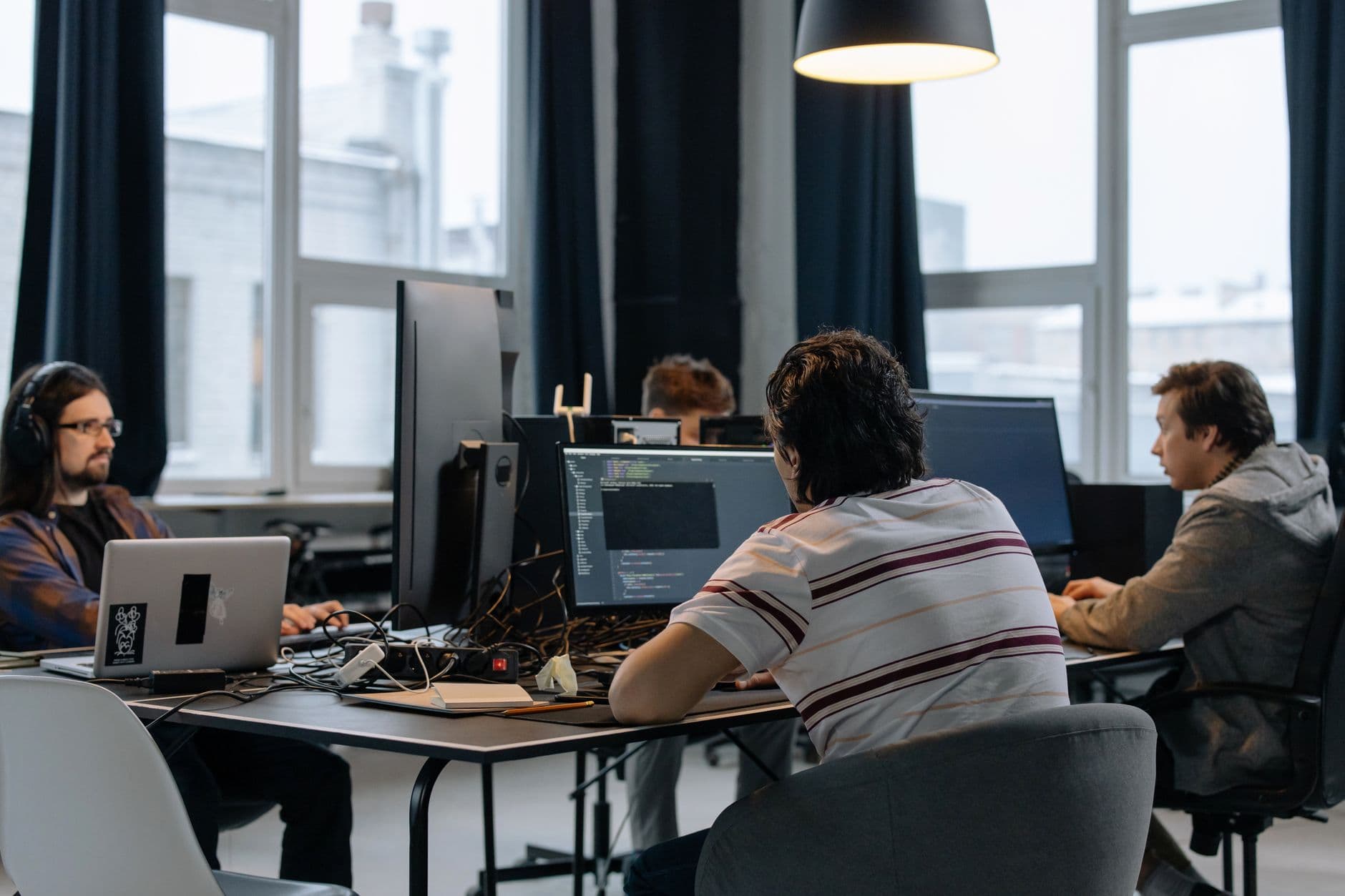 Equipo de desarrollo de software trabajando con computadoras en una oficina